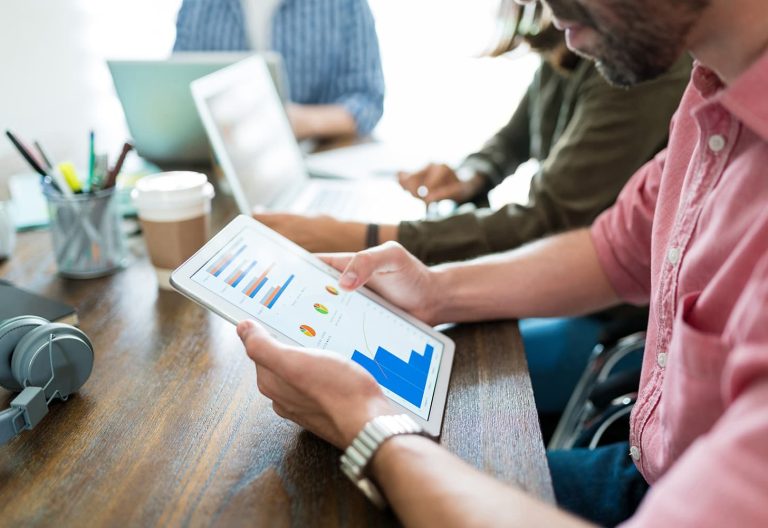 Business team reviewing growth charts on a tablet