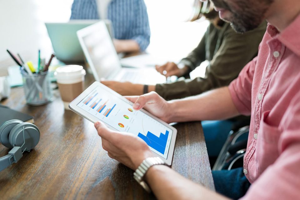 Business team reviewing growth charts on a tablet