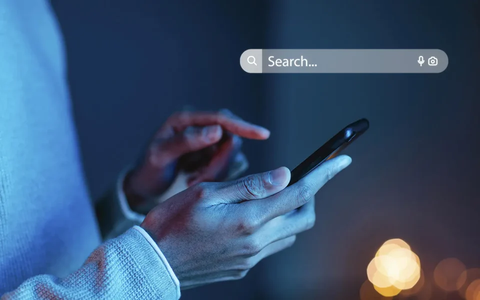 Person typing a question into a search bar on a smartphone