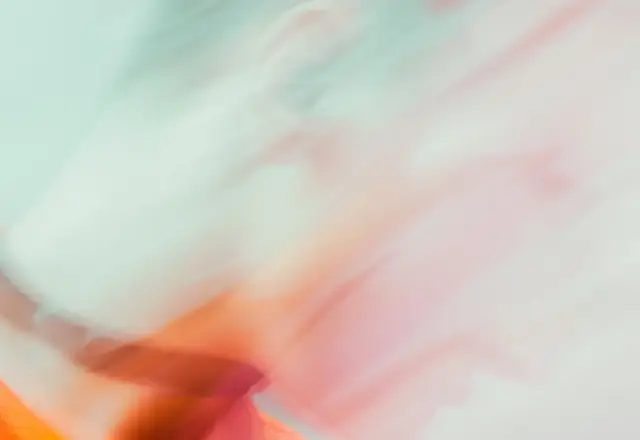 Mint and coral light trails from a figure in motion